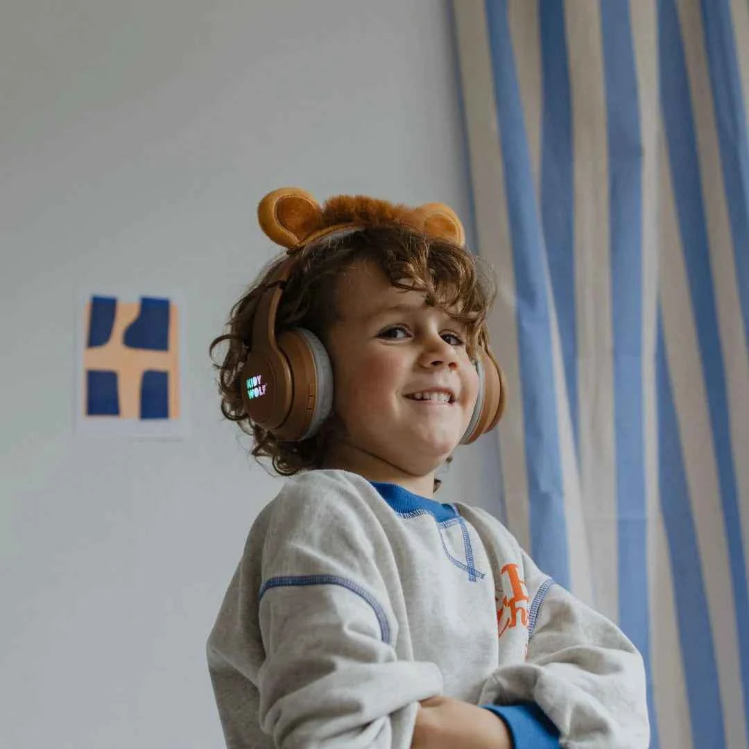 Kids' Bluetooth lion headphones on a child with tan ear cups and over-ear headband