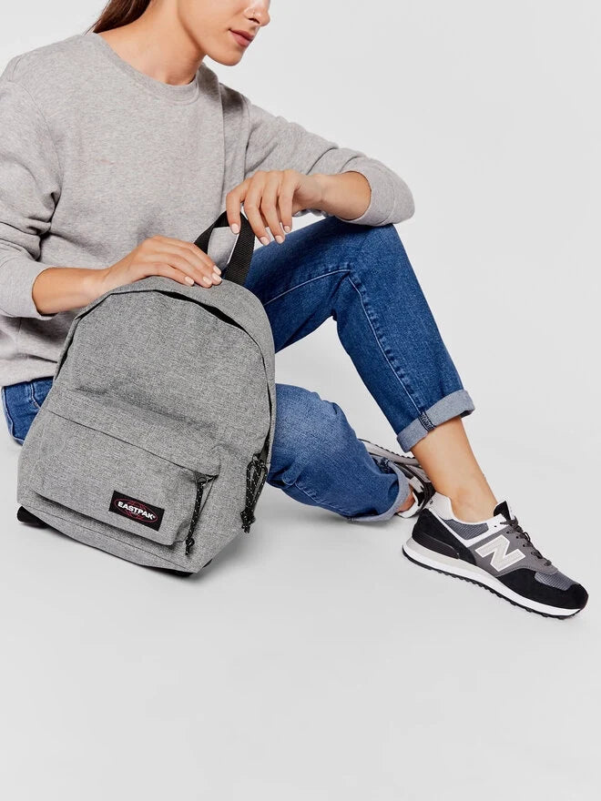 Person wearing Eastpak Sunday grey mini backpack with side zips and front pocket