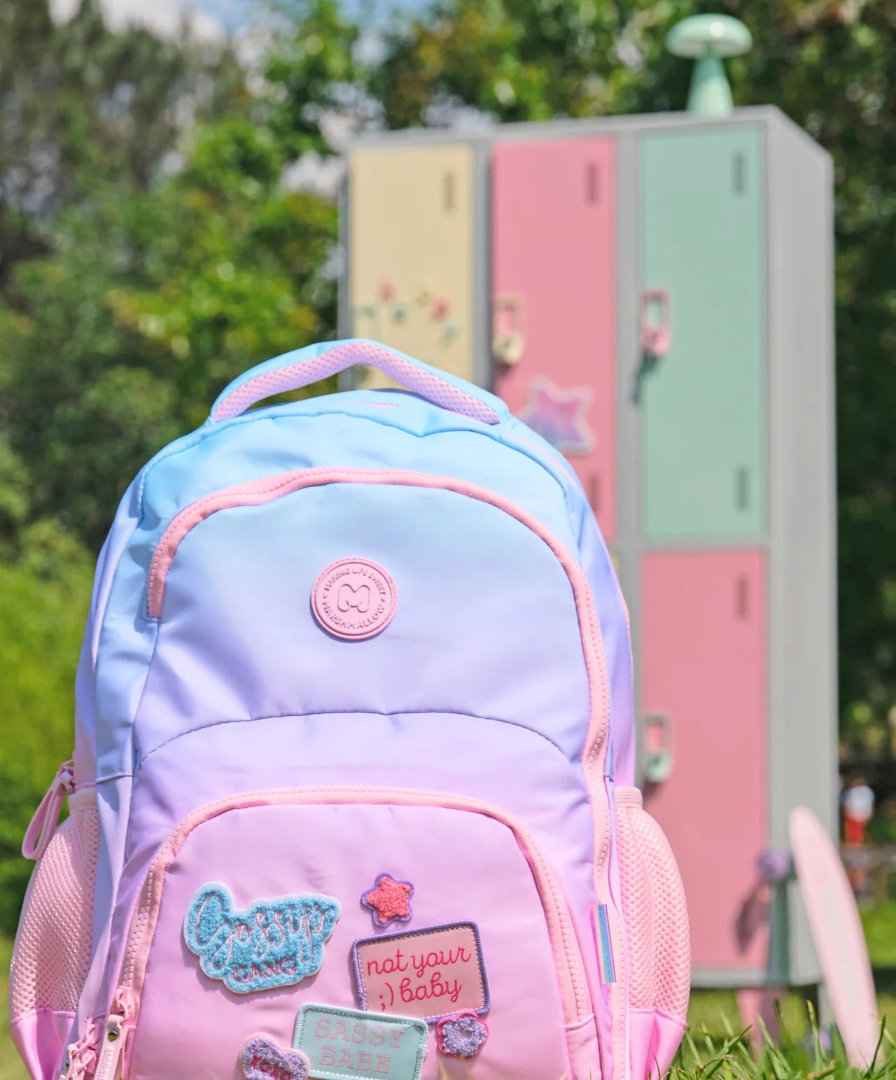 Light purple and blue backpack with pink edging, logo badge, side mesh pockets
