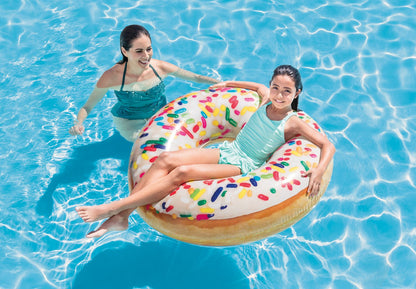 Inflatable donut pool float tube on water, white frosting with colorful sprinkles