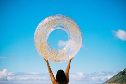 Glitter pool float ring, light blue with gold sparkle, held overhead