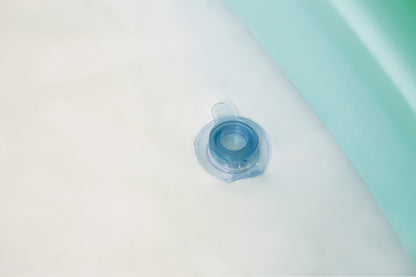 Pool drain plug and small valve on blue inflatable pool wall