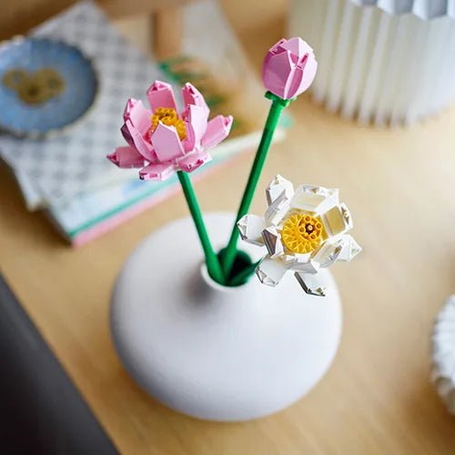 Lotus flowers bouquet with pink and white paper blooms in a white vase
