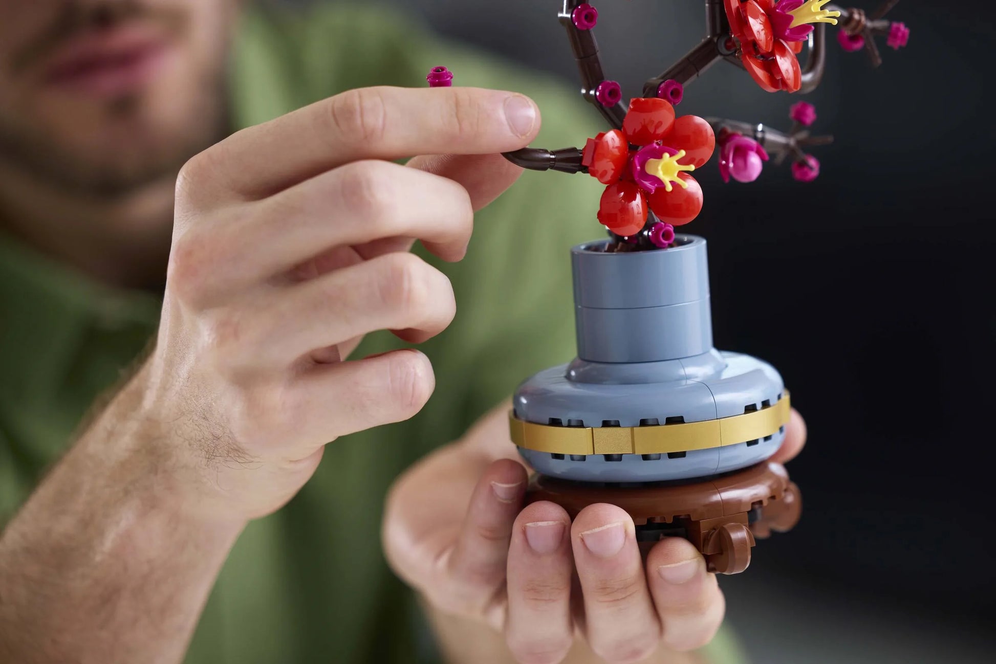 Plum blossom toy with red flowers on a blue base, held in hands