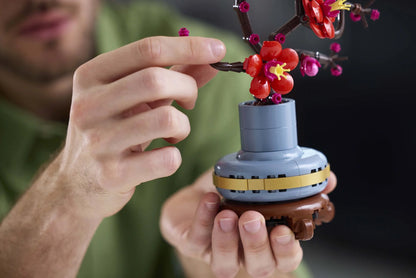 Plum blossom toy with red flowers on a blue base, held in hands