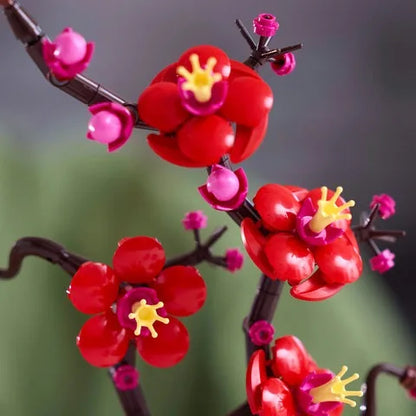 Plum blossom decoration with red flower clusters, pink stems, and yellow centers
