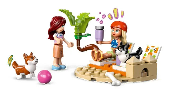 Toy building set with two minifigures, surfboard, dogs, and brick scooter play pieces