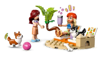 Toy building set with two minifigures, surfboard, dogs, and brick scooter play pieces