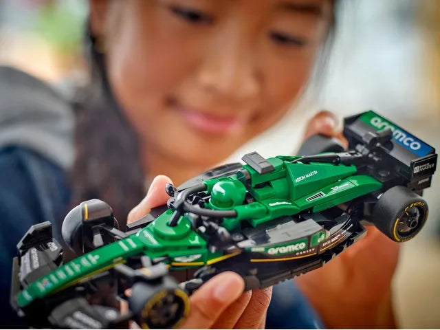 Green Formula race car model in a child’s hands