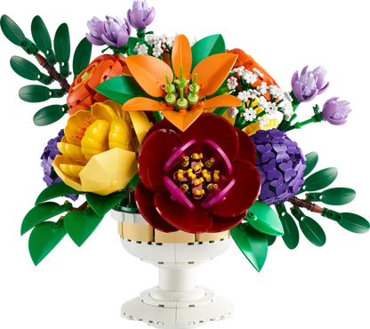 Flower arrangement centerpiece with large maroon bloom, orange and purple petals, green leaves