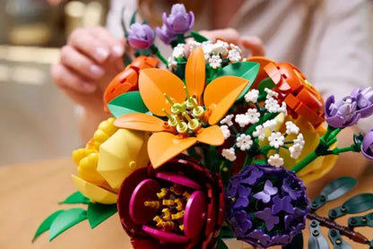 Colorful flower arrangement with orange, yellow, purple blooms and green leaves