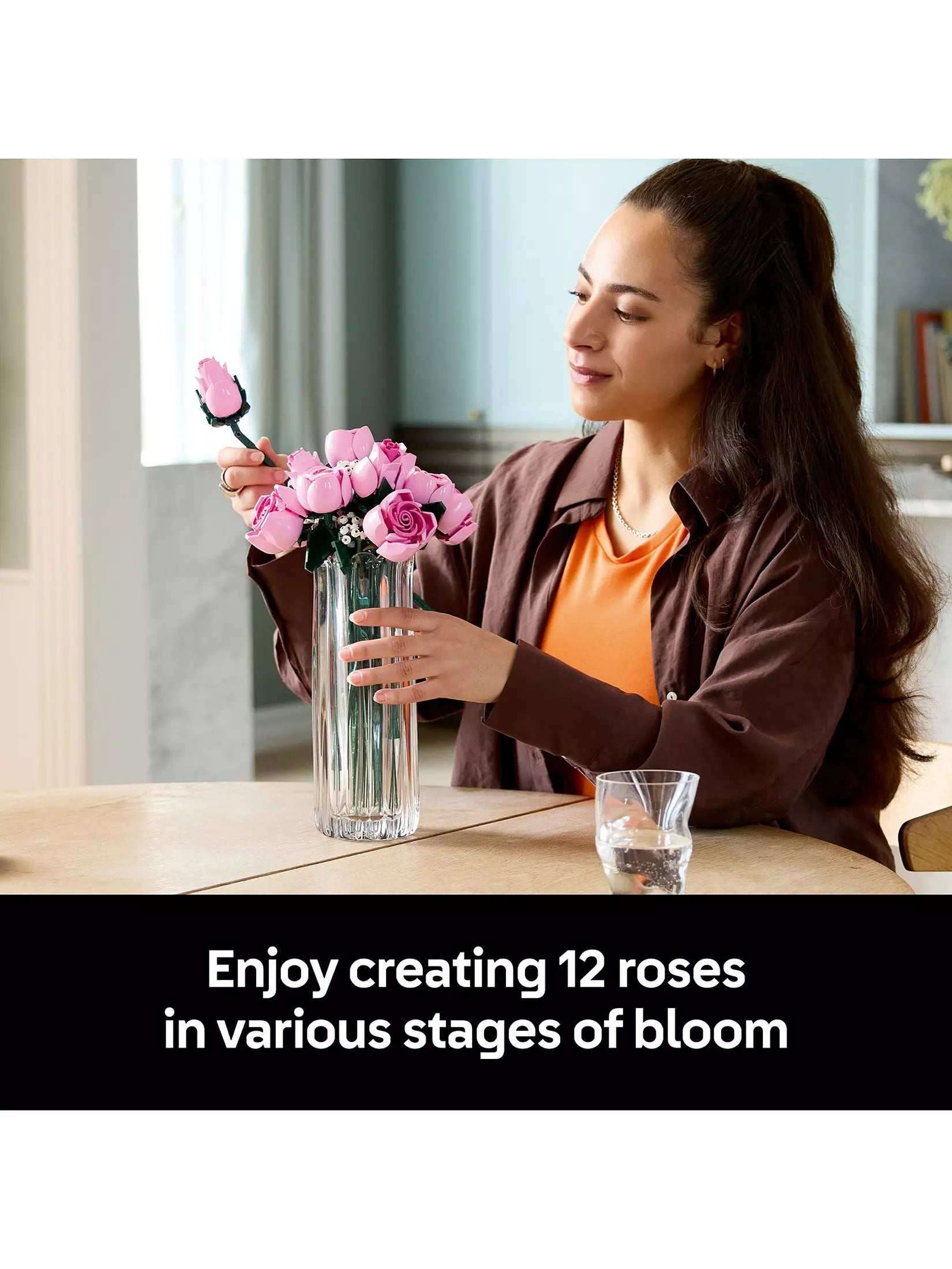 Pink rose bouquet with green stems and white filler flowers in clear vase