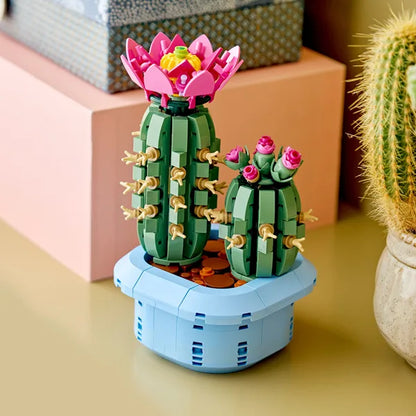 Flowering cactus model on blue base with green cacti and pink blooming flowers