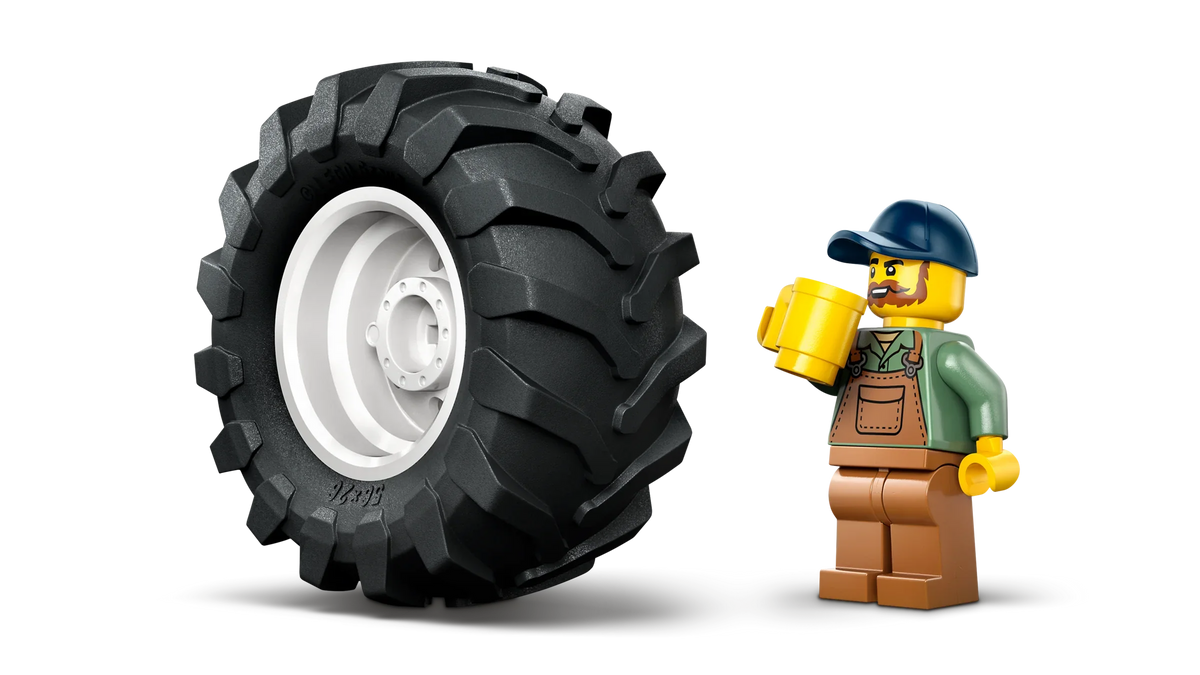 Tractor toy front wheel with tread and standing minifigure driver