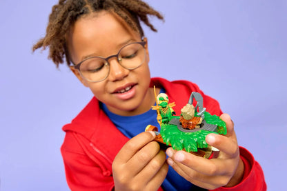 Kind hält grünen Erd-Monster-Spinner mit Lloyd-Miniﬁgur und kleinem Monster-Accessoire