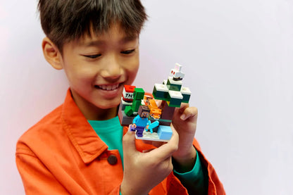 Child holding the Steve's Taiga Adventure LEGO build with small figures