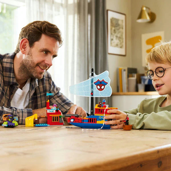 Team Spidey pirate ship toy in hands, with minifigures and build on the table