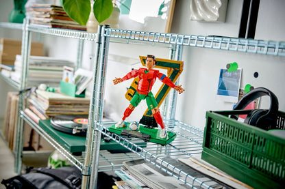 LEGO soccer legend figure displayed on a shelf stand with red jersey and green pants