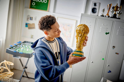 LEGO FIFA World Cup trophy held in a child’s hands, on a classroom desk