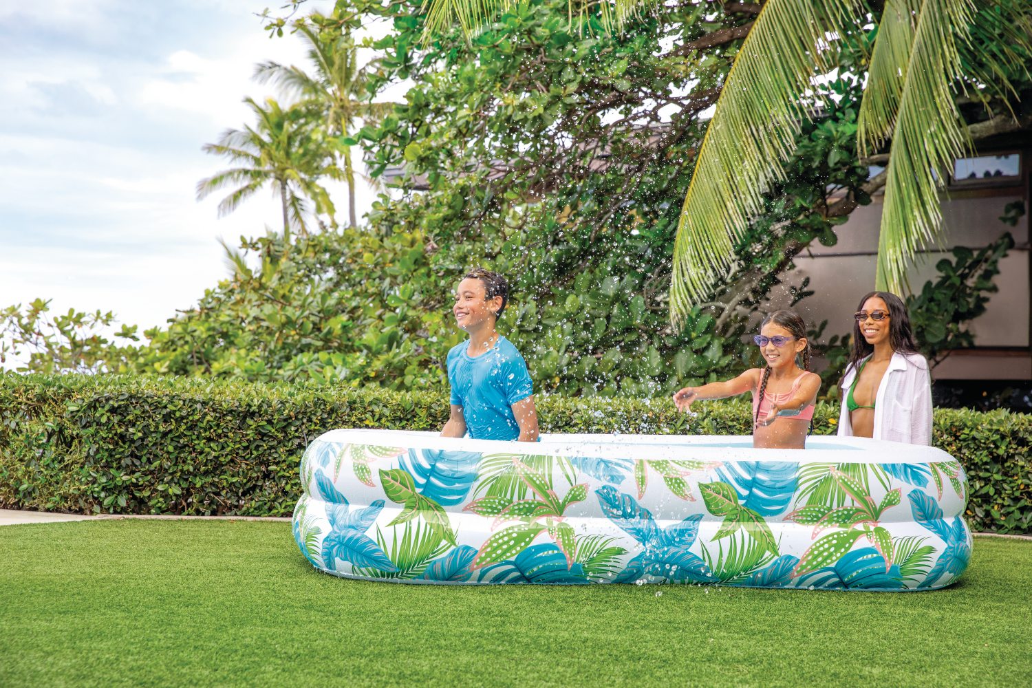 Inflatable family pool with wide tropical leaf pattern and blue interior basin