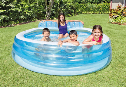 Inflatable round pool with blue water and white rim, family splashing