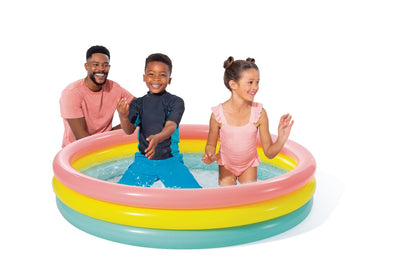 Inflatable pool with pink, yellow and teal rim; children playing in the water