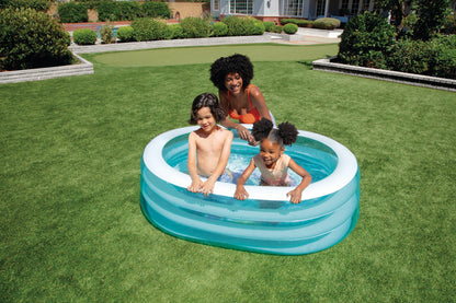 Inflatable sea-themed kids pool in backyard, with children playing in the water