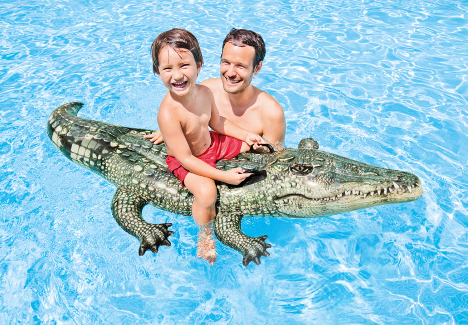Green gator ride-on toy with textured scales, carrying a child and adult