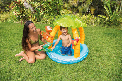 Tropical island baby pool with green umbrella canopy, yellow palm poles, and blue water ring