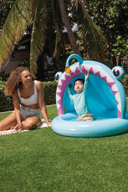Light blue inflatable baby pool shaped like a fish with purple toothy edge