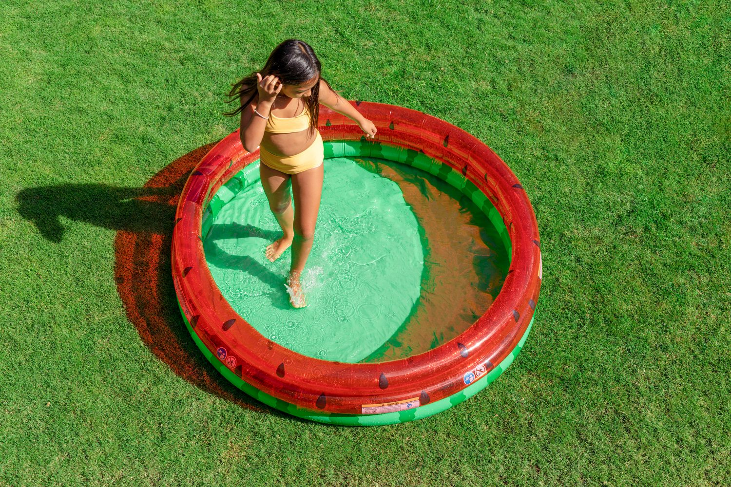 Watermelon pool with red-and-green inflatable walls and black seed dots, round