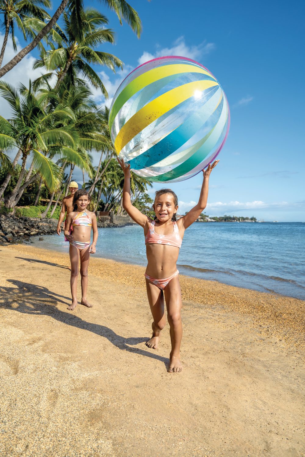 Jumbo beach ball with rainbow stripes, held overhead
