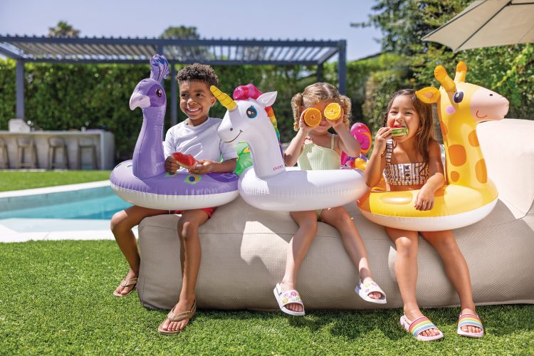 Kids using inflatable animal pool rings: giraffe, unicorn, purple sea creature