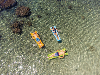Inflatable pool mattresses in blue and green used by swimmers floating on water
