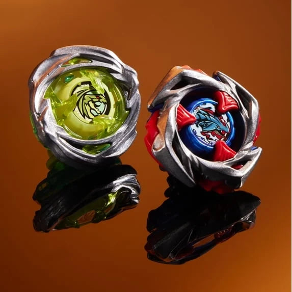 Pair of Beyblade tops with green and blue/red faces in metallic frames