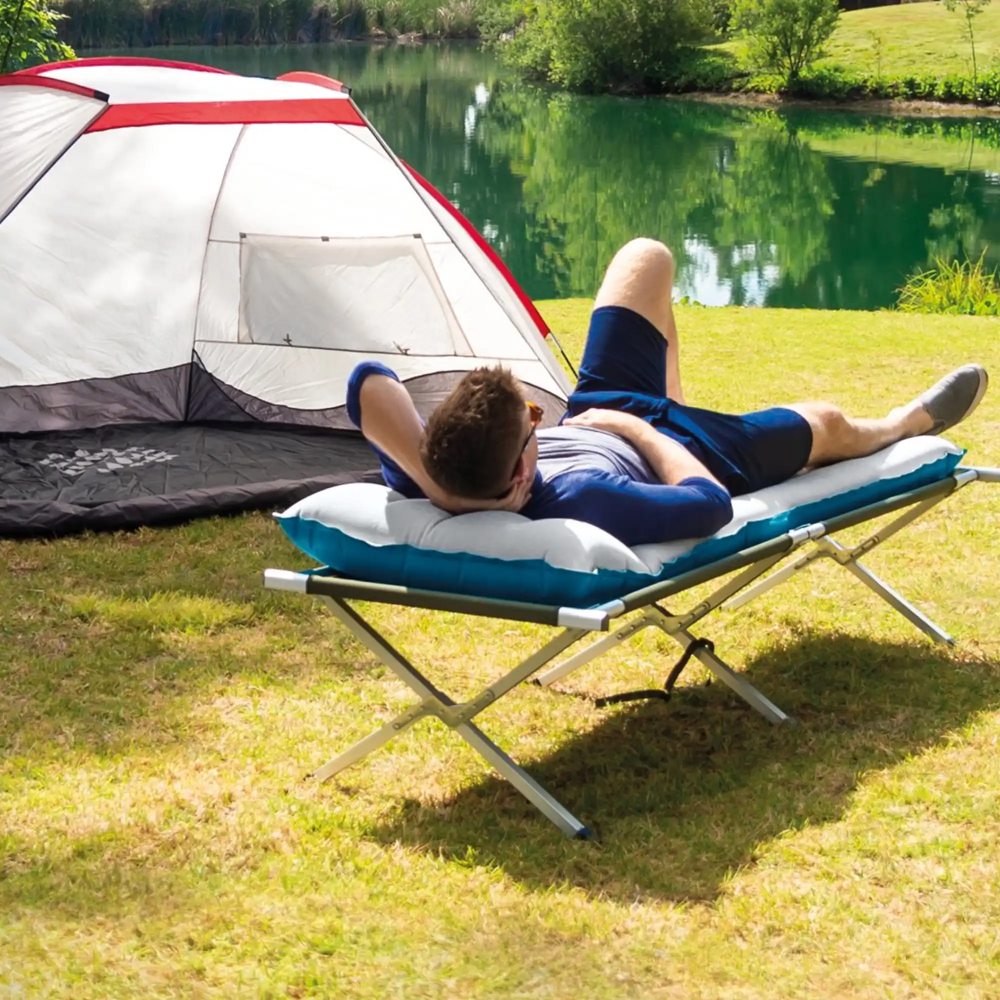 Camping mat on a folding lounge chair, light gray padded top with blue edges
