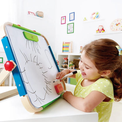 ANYWHERE ART STUDIO Zeichenbrett auf Ständer, Kind zeichnet mit Stift; Zubehör liegt am Brett