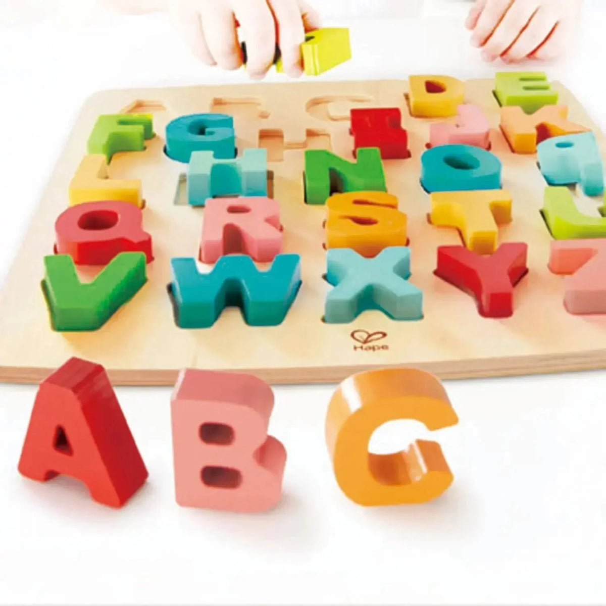 Wooden alphabet puzzle board with colorful chunky letter blocks, including A, B, and G