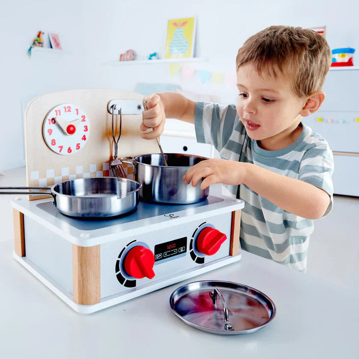Toy kitchen set with large pot and saucepan, clock face, red knobs