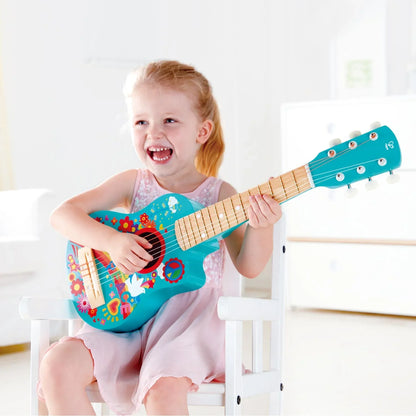 Turquoise toy guitar with rainbow flower and peace graphics, held by child