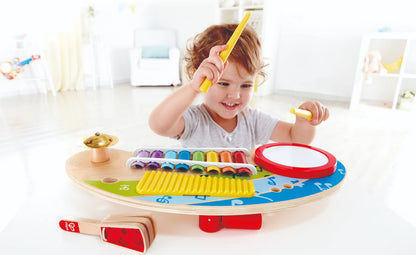 Child playing a wooden xylophone with colorful bars and a yellow mallet