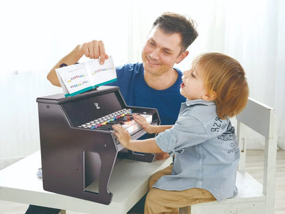 Toy keyboard playtime: child and parent with hands on the keys