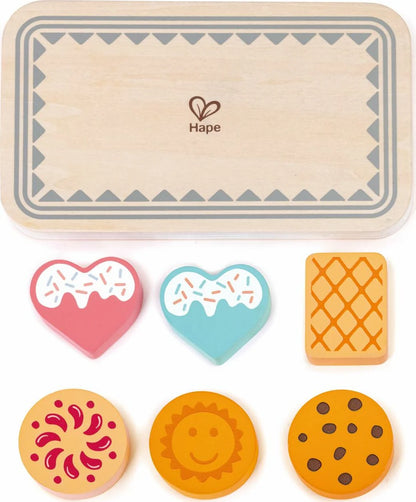 Wooden baking board with colorful cookie shapes: heart, waffle grid, sun and cookie