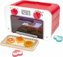 Red toy baking oven with open door, two knobs, and cookie pieces on a tray
