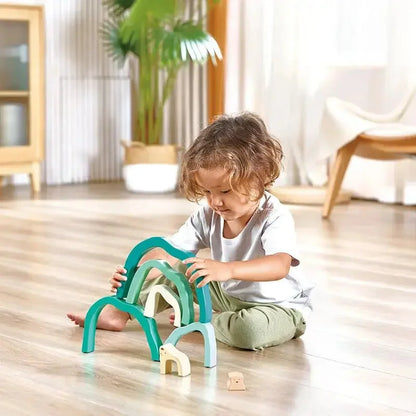 Teal stacking arch blocks with light wood pieces, toddler playing
