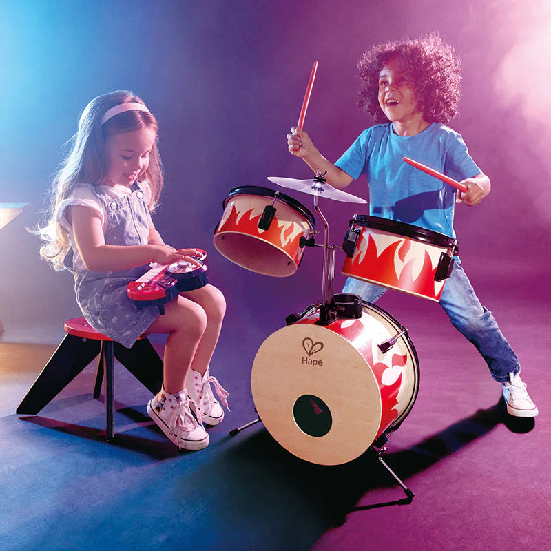 Flame drum set played by two kids, with cymbals and drumsticks on stands
