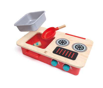 Play kitchen set with open pan, red pot, and stovetop burner tiles