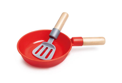 Red frying pan with wooden handles and slotted spatula tool