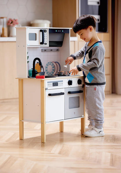 Spielküche Modern Smart-Kitchen im Kinderzimmer, Kind steht am geöffneten Herd