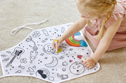 White coloring apron with colorful doodle print, spread out with marker in use